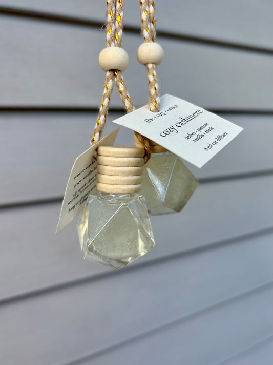 Decorative hanging item with geometric glass pendant and wooden beads on a neutral background