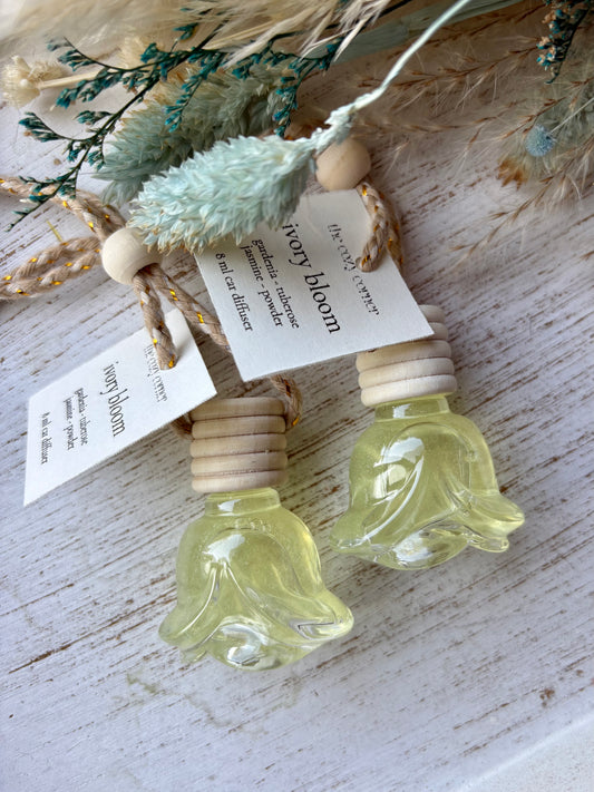 Two small glass bottles with wooden caps on a rustic wooden surface, labeled 'Terry Bloom'.