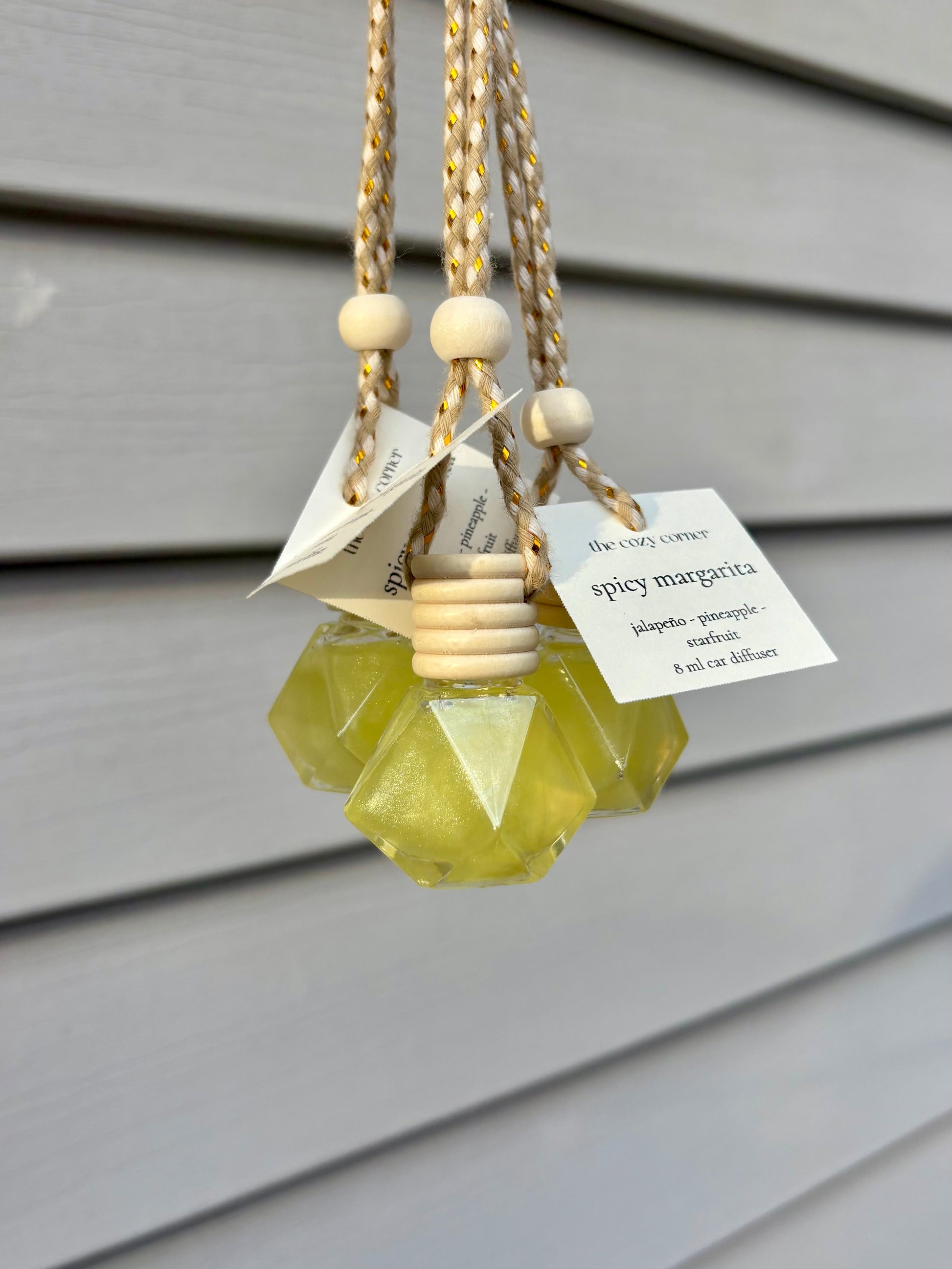 Decorative hanging diffuser with geometric design and wooden beads on a neutral background