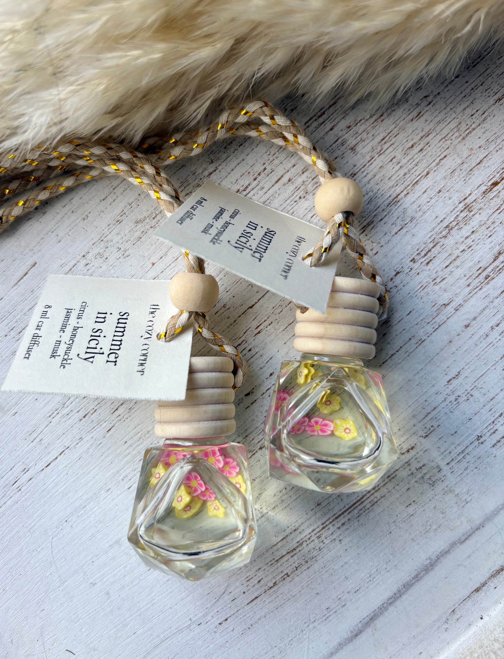 Two small glass bottles with wooden caps on a textured surface