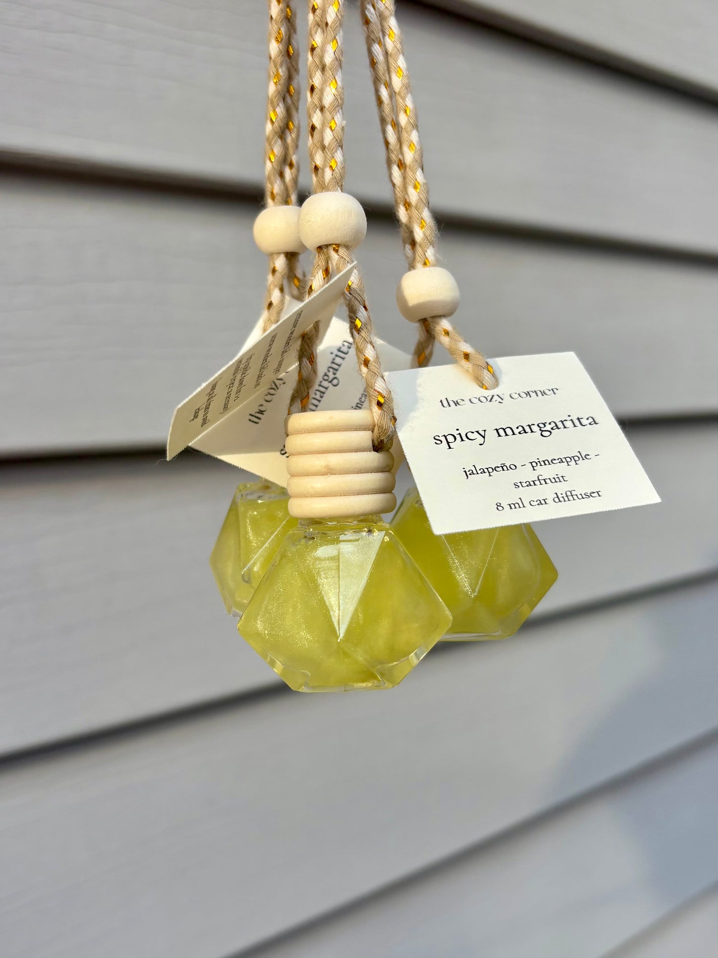 Decorative hanging diffuser with a yellow gem-like design on a neutral background