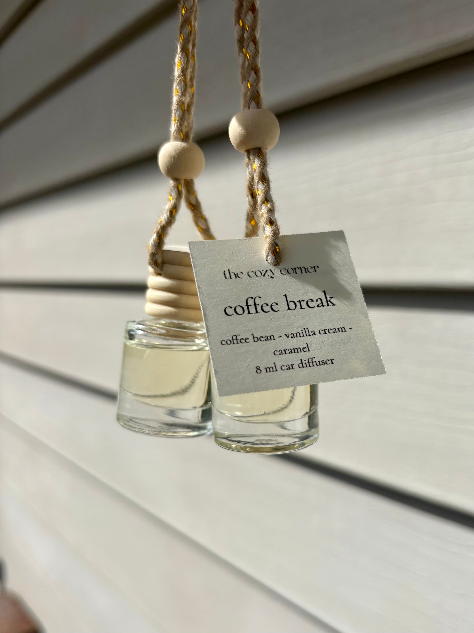 Two glass diffusers with wooden beads hanging on a string, labeled 'coffee break'.