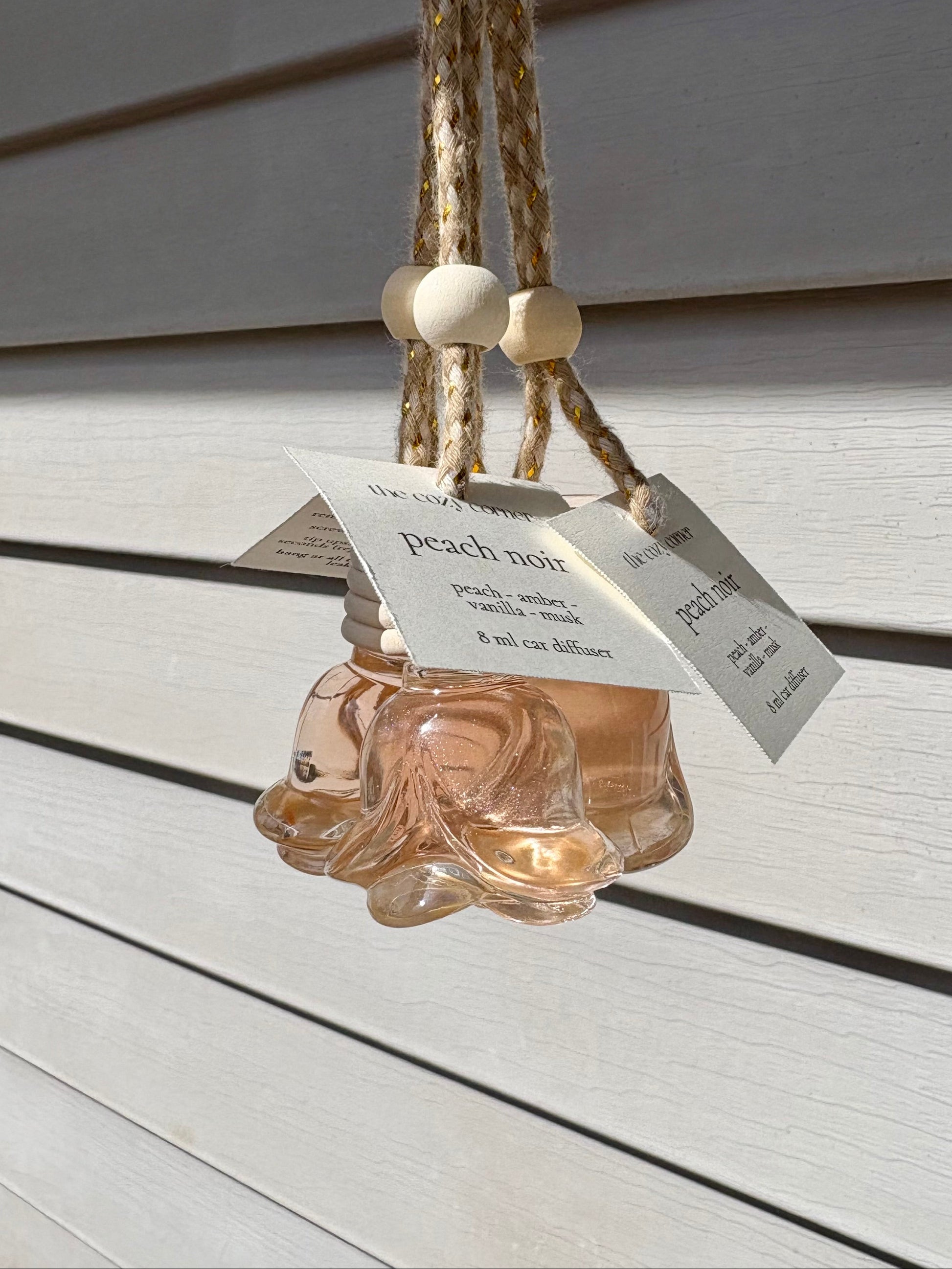 Glass hanging diffuser with a label on a wooden surface